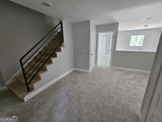 staircase featuring carpet, visible vents, and baseboards