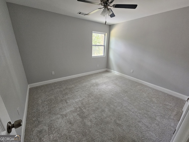 empty room featuring carpet floors, visible vents, ceiling fan, and baseboards