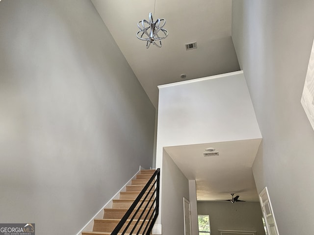 stairs with visible vents and ceiling fan with notable chandelier