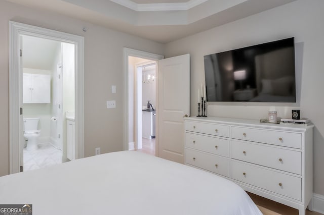 bedroom featuring a tray ceiling and ensuite bath