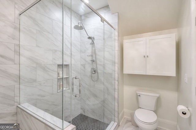 full bathroom with a stall shower, toilet, and baseboards