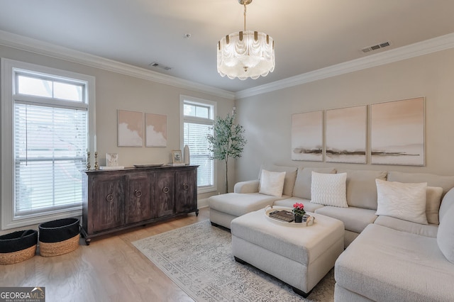 living area featuring visible vents, light wood-type flooring, and crown molding