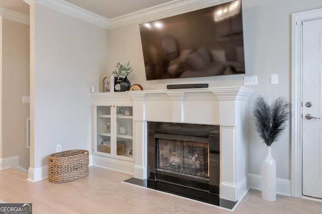 details featuring visible vents, ornamental molding, wood finished floors, a fireplace, and baseboards