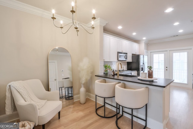 kitchen featuring refrigerator with ice dispenser, stainless steel microwave, dark countertops, arched walkways, and range