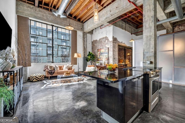 kitchen with concrete floors, dark countertops, stainless steel electric range, and a high ceiling