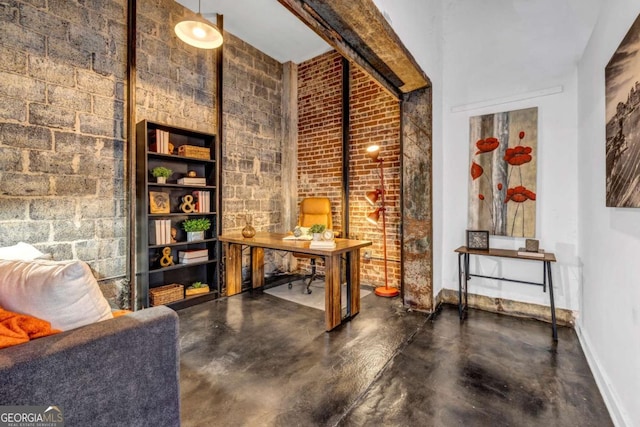 wine area featuring baseboards, brick wall, and finished concrete floors