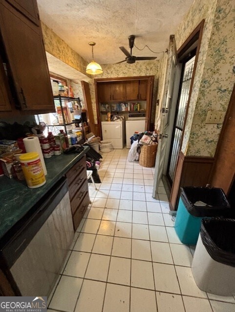 interior space with a wainscoted wall, a textured ceiling, separate washer and dryer, wallpapered walls, and dishwashing machine