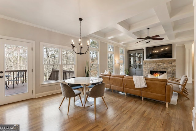 dining area with coffered ceiling, wood finished floors, a fireplace, and ornamental molding