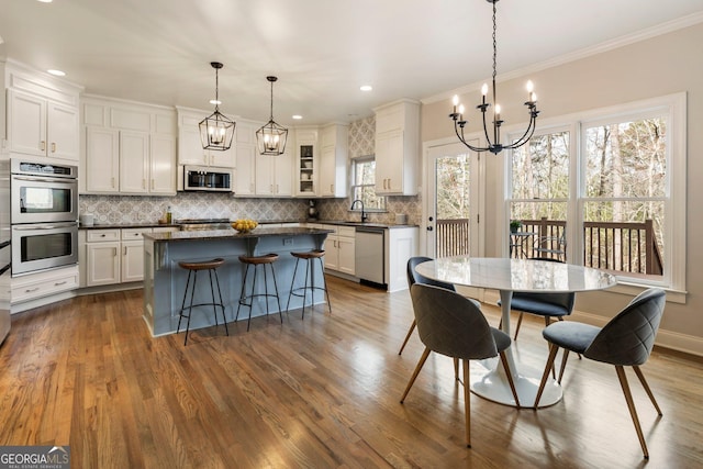 dining room with baseboards, ornamental molding, recessed lighting, an inviting chandelier, and dark wood-style flooring