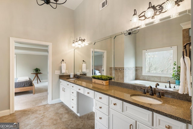 ensuite bathroom with double vanity, visible vents, ensuite bathroom, and a sink