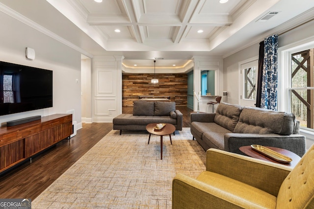 living room featuring an accent wall, dark wood-type flooring, crown molding, beamed ceiling, and coffered ceiling