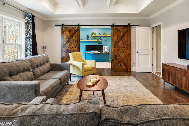 living room with ornamental molding, a barn door, and wood finished floors