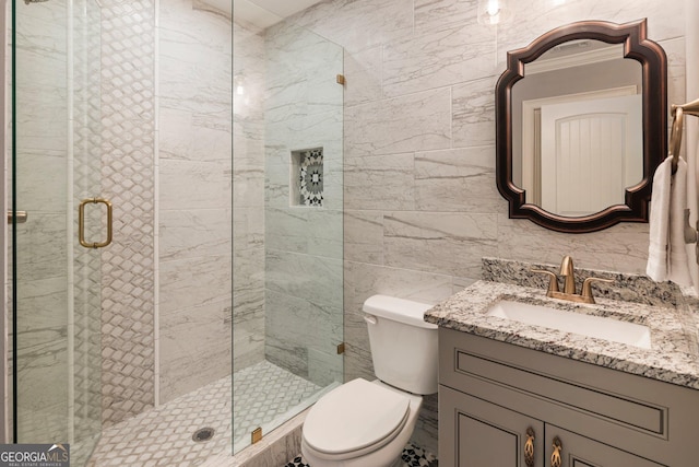 full bathroom with toilet, tile walls, a stall shower, and vanity