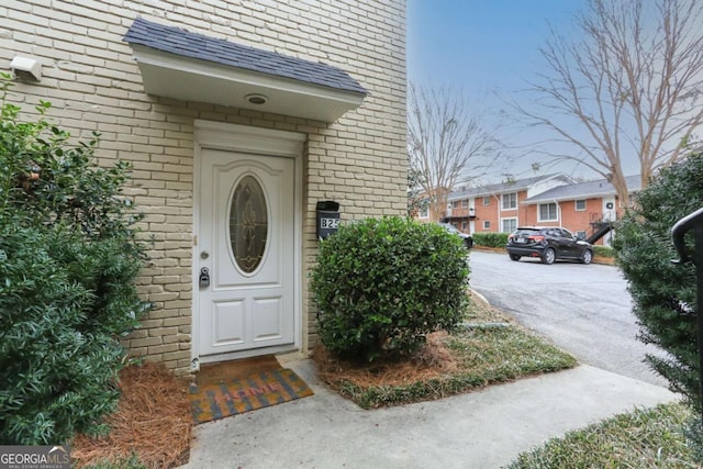 property entrance with a residential view and brick siding