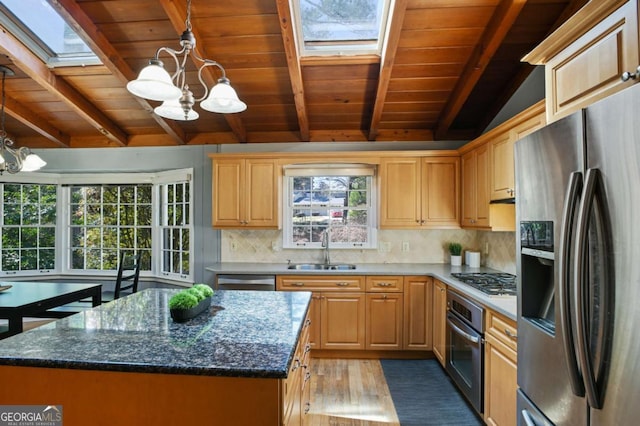 kitchen featuring stainless steel appliances, a chandelier, a sink, and decorative backsplash