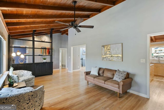 living room featuring baseboards, wood ceiling, ceiling fan, light wood-style floors, and beam ceiling