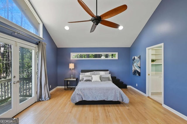 bedroom with multiple windows, wood finished floors, and access to exterior