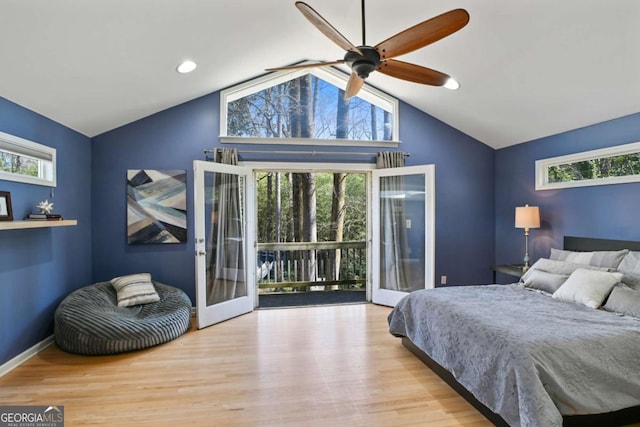 bedroom featuring access to outside, multiple windows, baseboards, and wood finished floors