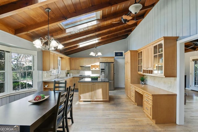 kitchen with a notable chandelier, a sink, backsplash, and stainless steel fridge with ice dispenser