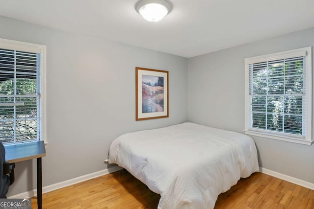 bedroom with light wood-type flooring and baseboards