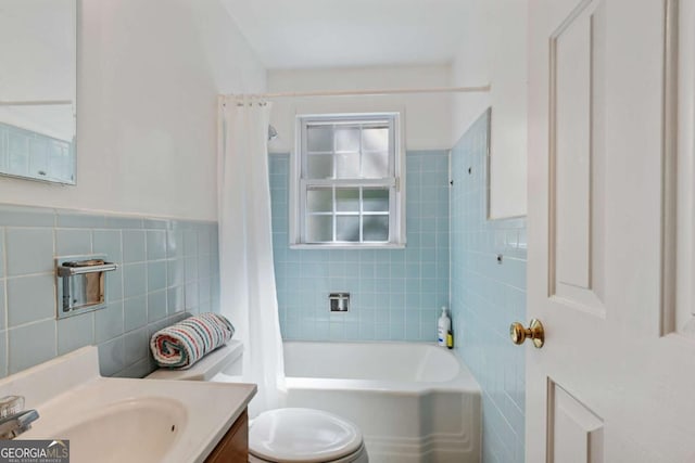 full bathroom with shower / tub combo with curtain, tile walls, toilet, and vanity