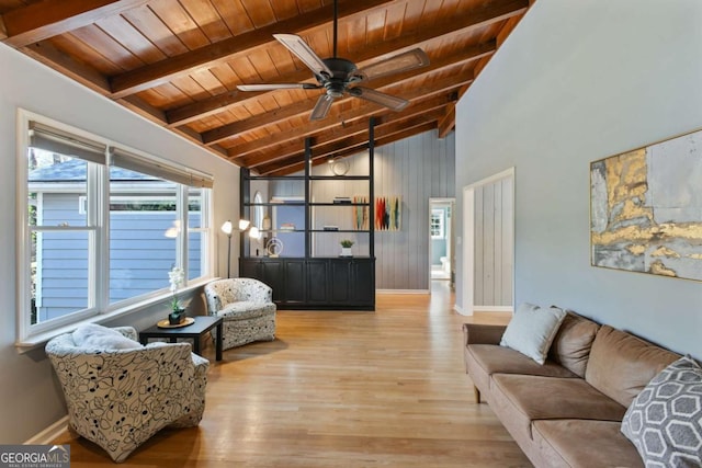 living area with lofted ceiling with beams, ceiling fan, wooden ceiling, baseboards, and light wood-style floors