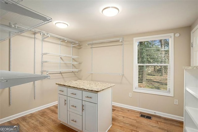 spacious closet with light wood-style flooring and visible vents