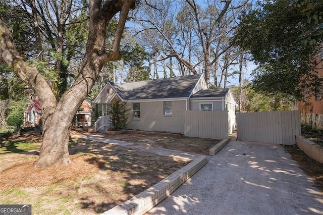 exterior space featuring driveway, fence, and a gate