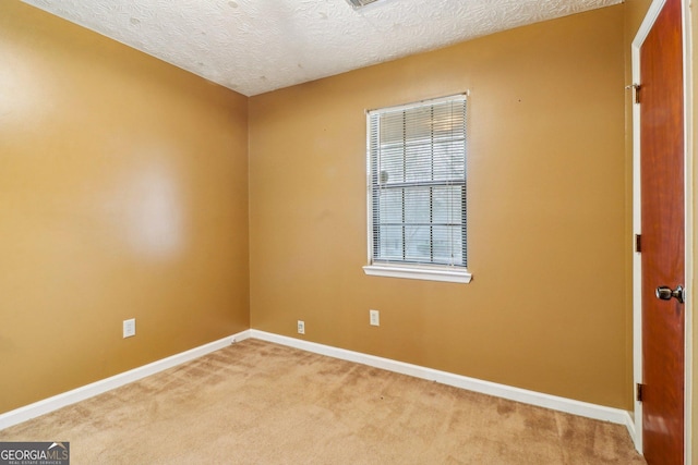 unfurnished room featuring light carpet, a textured ceiling, and baseboards