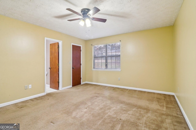 unfurnished bedroom featuring a textured ceiling, ceiling fan, carpet flooring, and baseboards