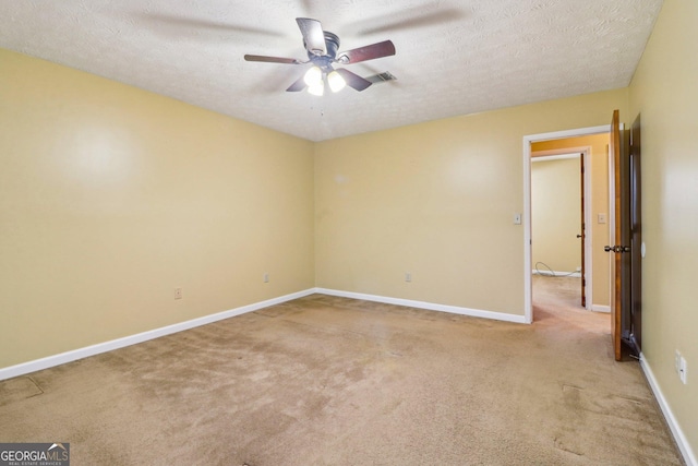 unfurnished room with carpet, visible vents, a ceiling fan, a textured ceiling, and baseboards