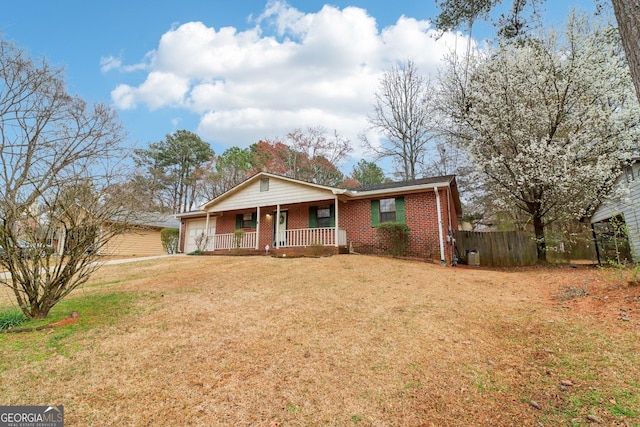 view of front of home with a porch, a garage, brick siding, fence, and a front lawn