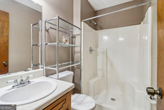 full bathroom featuring a stall shower, vanity, and toilet