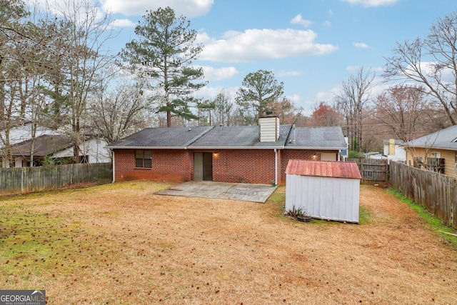 back of property featuring a patio area, an outbuilding, a lawn, and brick siding