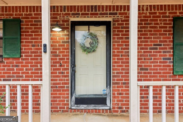 property entrance featuring brick siding