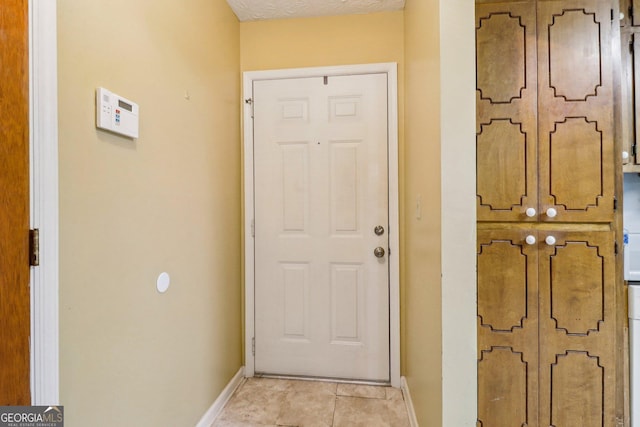 doorway to outside featuring baseboards