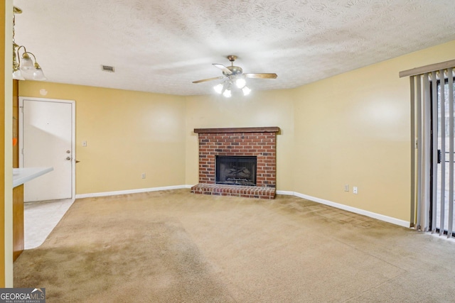 unfurnished living room with carpet floors, a fireplace, a ceiling fan, a textured ceiling, and baseboards