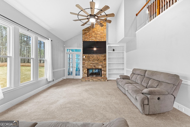 living room featuring baseboards, ceiling fan, carpet flooring, a stone fireplace, and high vaulted ceiling