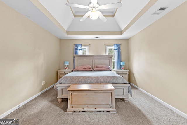 unfurnished bedroom with carpet floors, a raised ceiling, visible vents, and baseboards