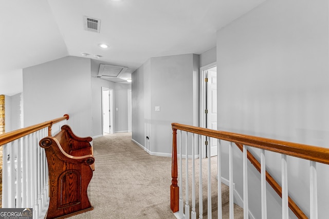 corridor with visible vents, attic access, carpet flooring, an upstairs landing, and baseboards