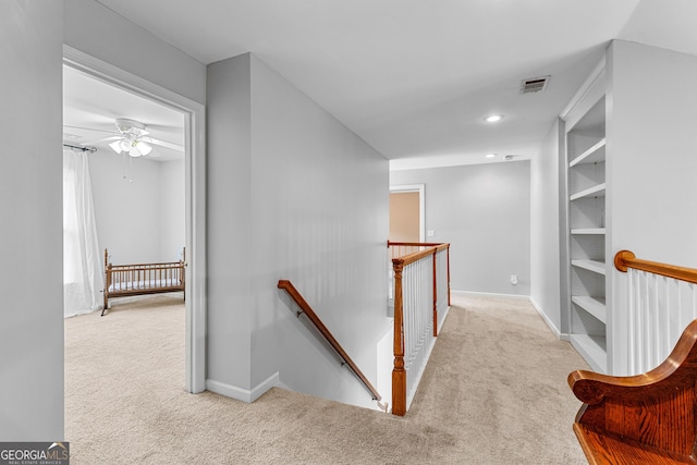 corridor featuring visible vents, carpet flooring, an upstairs landing, and baseboards