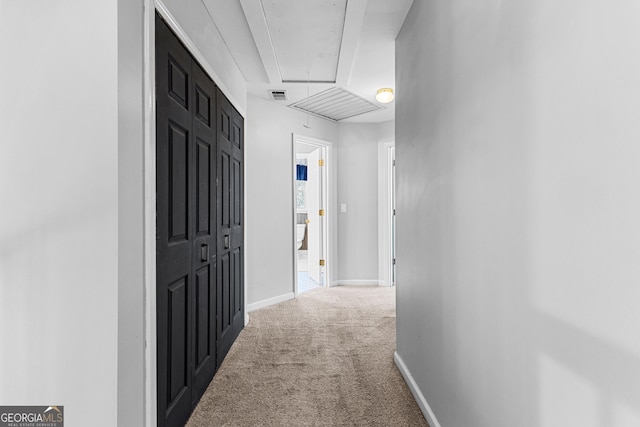 hallway featuring visible vents, carpet floors, attic access, and baseboards