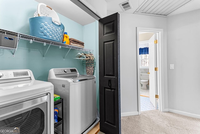 clothes washing area featuring light carpet, laundry area, baseboards, visible vents, and washing machine and clothes dryer