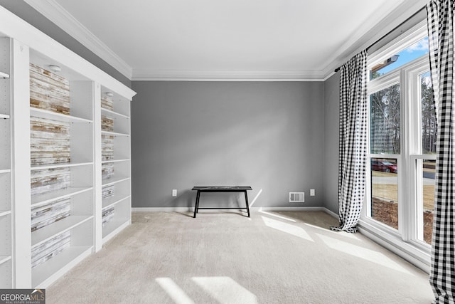 carpeted spare room featuring baseboards, visible vents, and crown molding