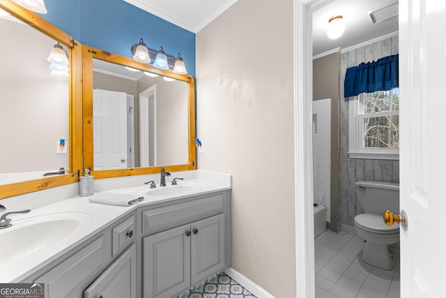 full bath with toilet, double vanity, ornamental molding, and a sink