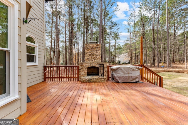 wooden deck with an outdoor stone fireplace