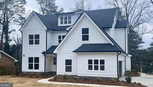 modern farmhouse with a shingled roof and board and batten siding