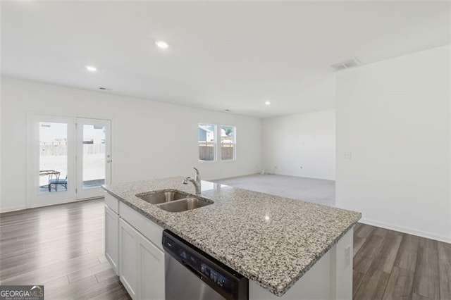 kitchen with light stone counters, wood finished floors, a sink, white cabinetry, and stainless steel dishwasher