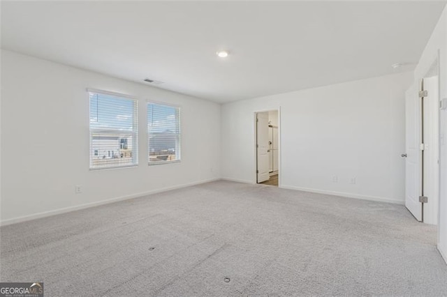 spare room featuring carpet and baseboards