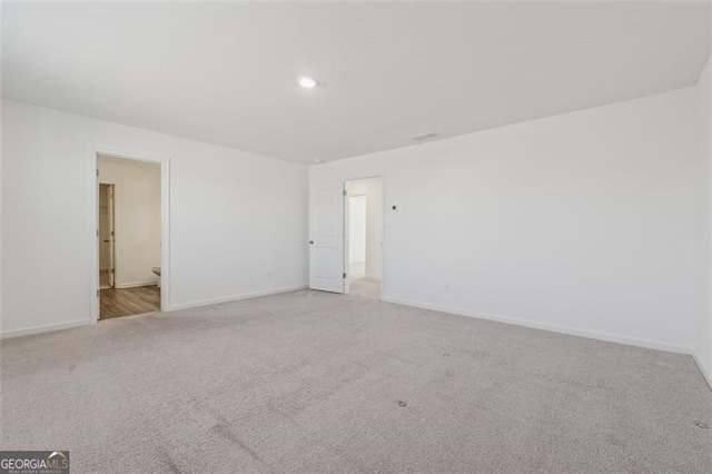 empty room featuring baseboards and carpet flooring